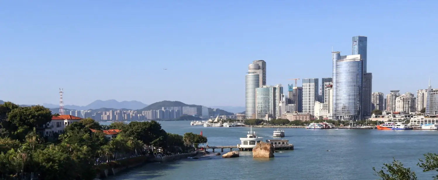 An image to describe 厦门的海边：依山傍水，有红瓦白墙，也有高楼林立，一幅海滨城市的样貌杂烩🏖️